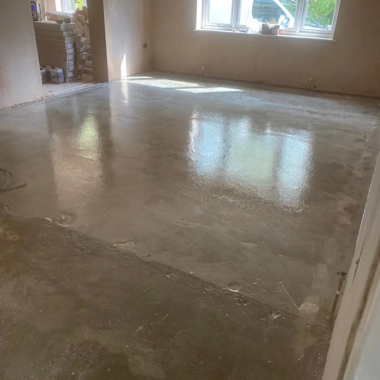 A freshly poured floor screed in a room under renovation