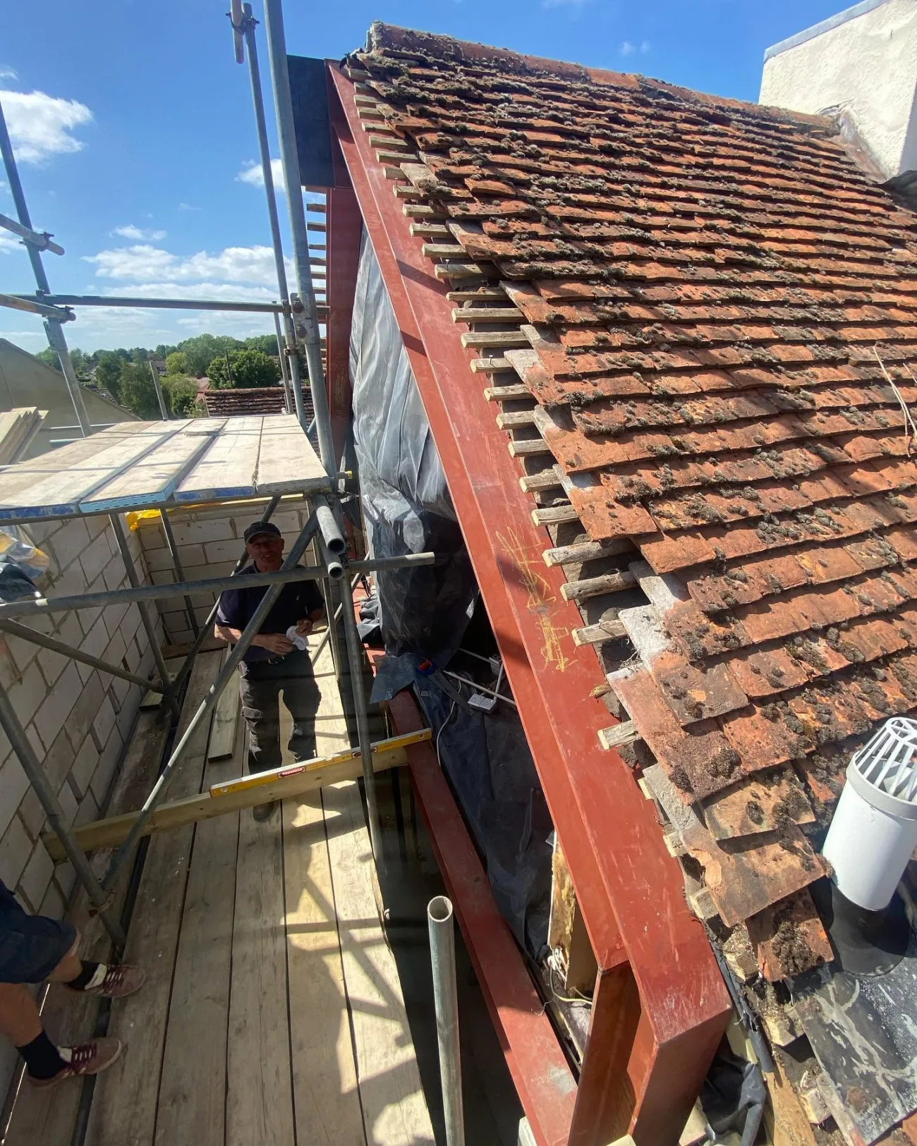 Stripping and re-laying an old clay-tiled roof from the scaffold