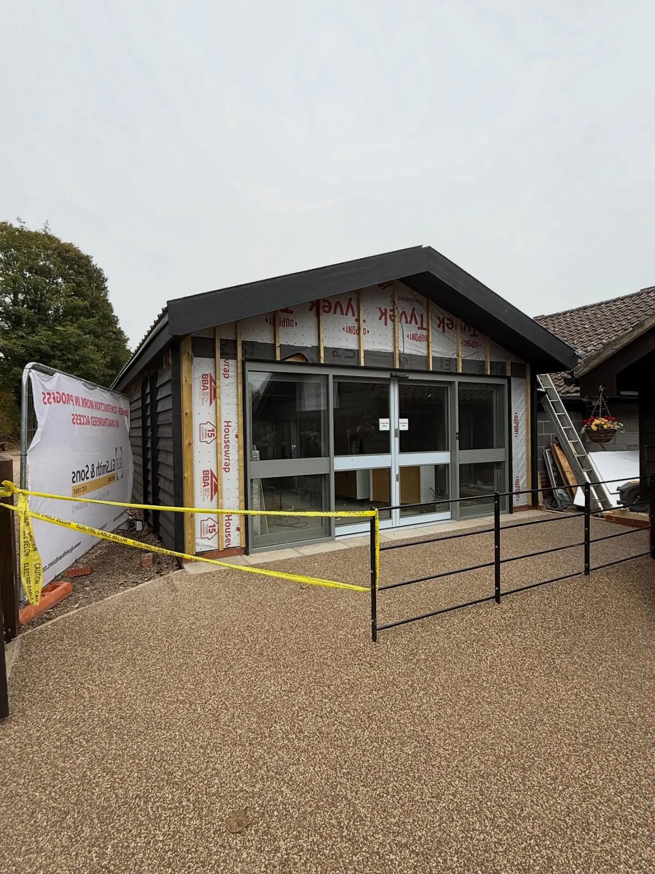 A contemporary clad building with a standing-seam roof, nearing completion