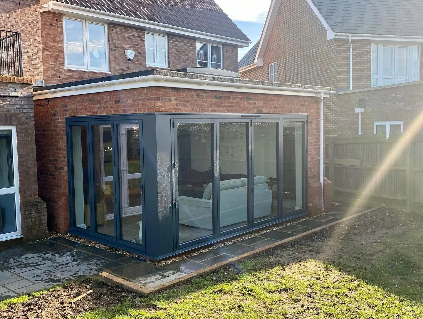 A family home with a glazed garden-room extension and bi-fold doors onto the lawn, built by G.L. Smith & Sons