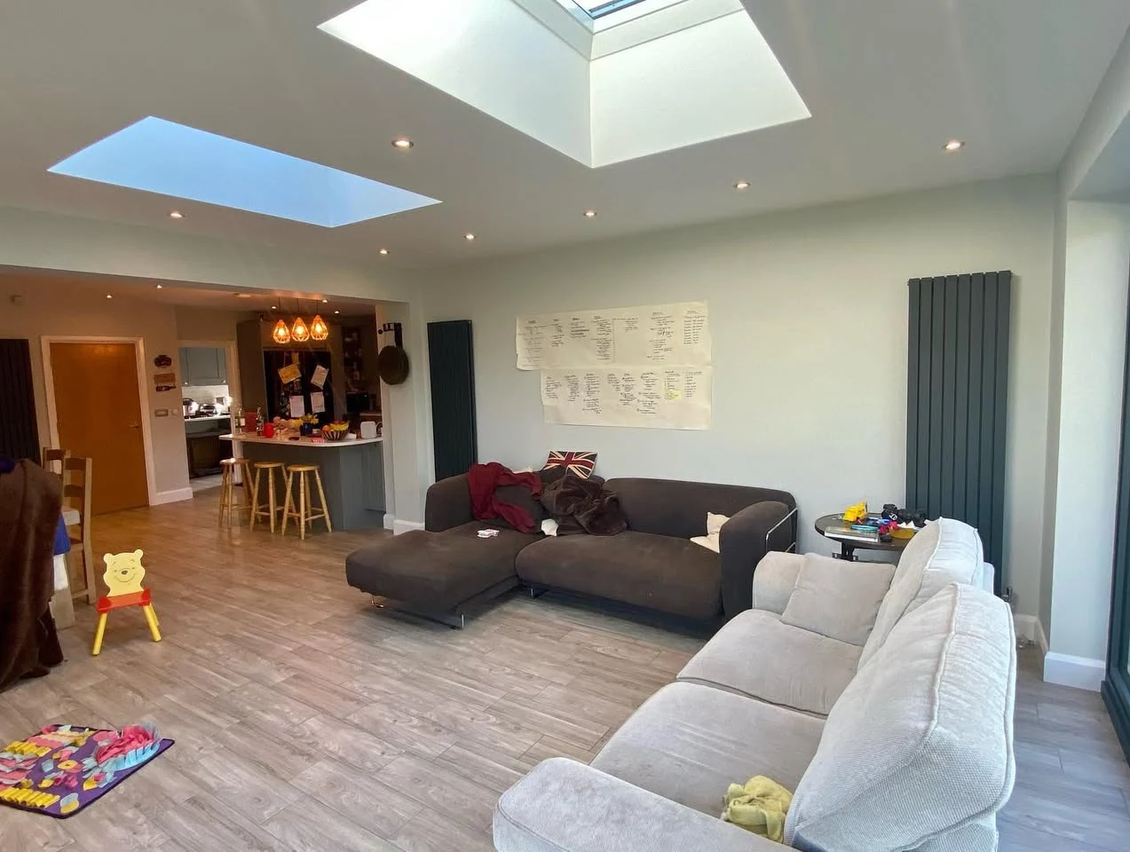 A bright open-plan living and kitchen extension lit by twin roof lanterns