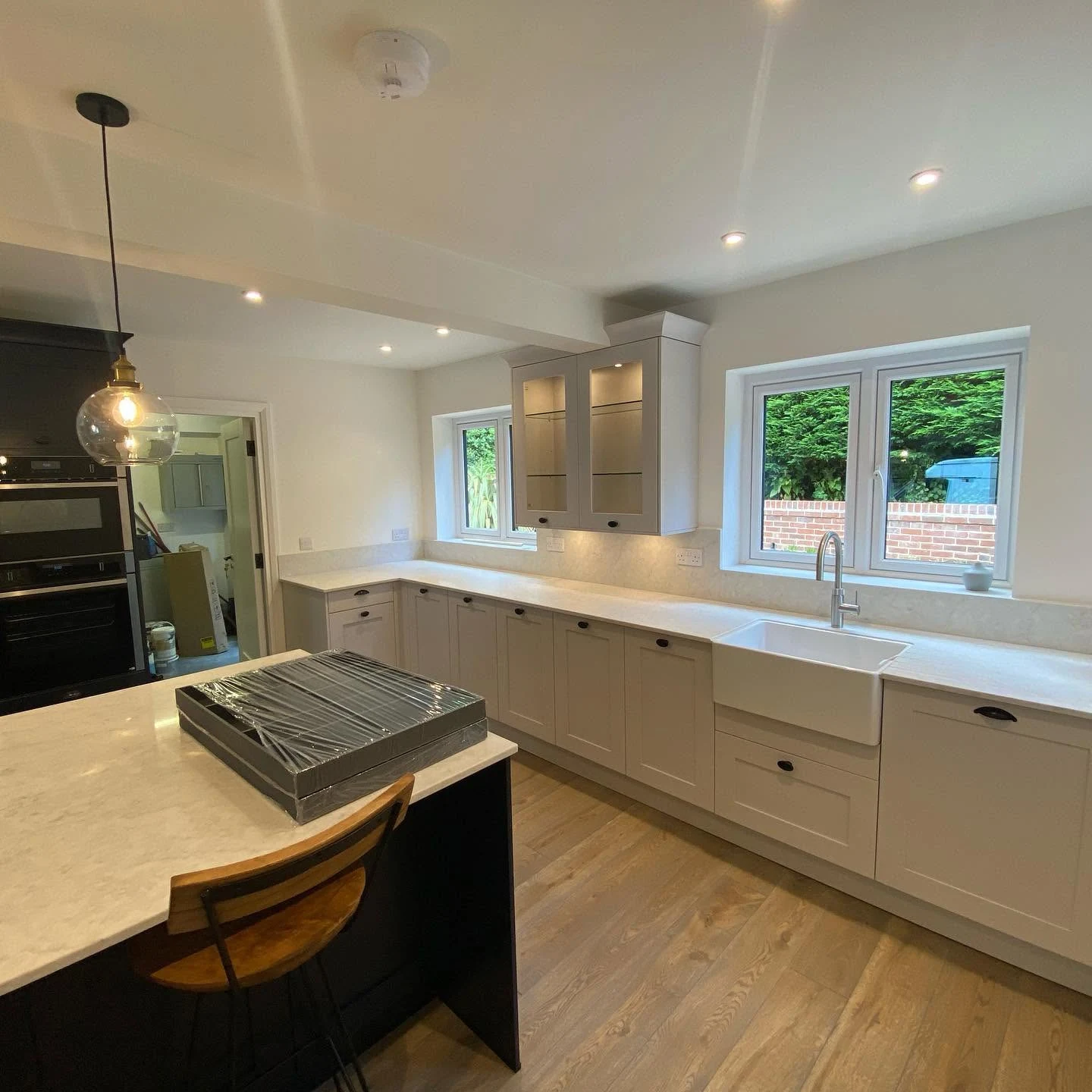 A finished kitchen with a central island, shaker units and quartz worktops