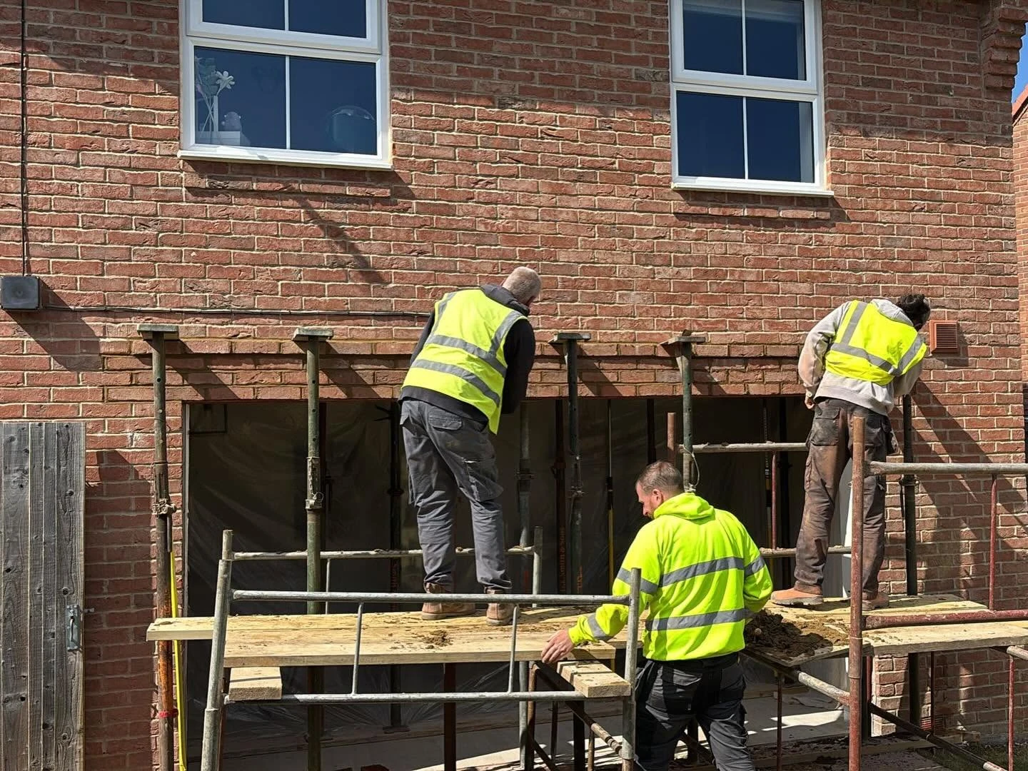 The G.L. Smith & Sons team at work on the rear of a brick home